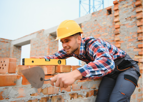 Construction worker lays out bricks